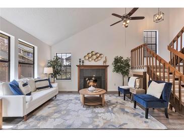Inviting living room features vaulted ceiling, fireplace, and staircase at 10836 W Evans Ave # 32, Lakewood, CO 80227