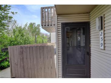 View of the front door and balcony on a two-story home with a wooden fence at 3550 S Harlan St # 259, Denver, CO 80235