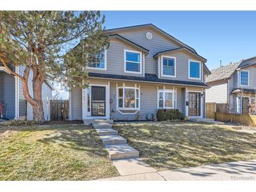 Charming gray townhome with a manicured lawn, steps leading to the front door, and a mature tree at 2163 S Grant St, Denver, CO 80210