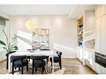 Bright dining room features a modern table, stylish chairs, zebra-print rug, and contemporary light fixture at 2659 S Cherokee St, Denver, CO 80223