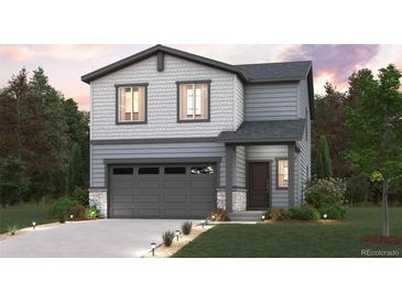 Charming two-story home features a gray exterior, a two-car garage, and a well-maintained front lawn at 2169 Flower Blossom Ave, Brighton, CO 80601