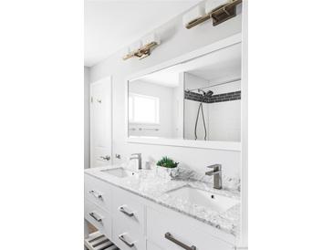 Elegant bathroom with double sinks, marble countertop, and a walk-in shower at 11354 Allendale Dr, Arvada, CO 80004