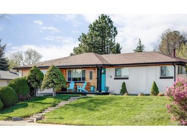 Charming home featuring a vibrant blue door, lush lawn, and inviting front porch with comfortable seating at 11354 Allendale Dr, Arvada, CO 80004