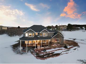 Stunning two-story home featuring a spacious wrap-around porch and meticulous landscaping, perfect for relaxing outdoors at 931 Forest View Rd, Monument, CO 80132