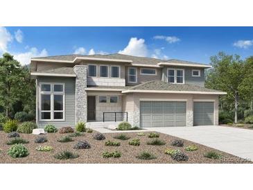Charming two-story home with stone accents, gray siding, a well-kept yard, and a three car attached garage at 3768 Backslope Ln, Castle Rock, CO 80108