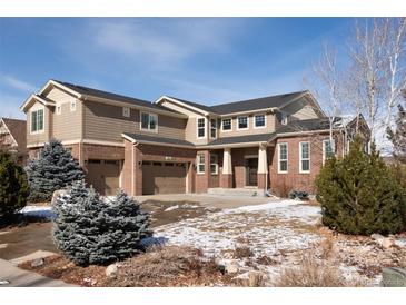 Inviting two-story home with a three-car garage and a well-maintained front yard at 17853 W 77Th Ln, Arvada, CO 80007