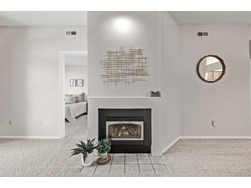 Living room features a modern fireplace, neutral paint and carpet, and decorative accents at 7481 Singing Hills Dr, Boulder, CO 80301