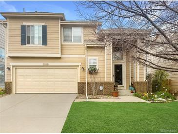 Charming two-story home with a well-maintained lawn, a two-car garage, and mature landscaping at 9469 W Ute Dr, Littleton, CO 80128