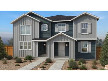 Charming two-story home showcasing gray and blue siding, white trim, and a well-manicured front yard at 2234 Farmlore Dr, Brighton, CO 80601