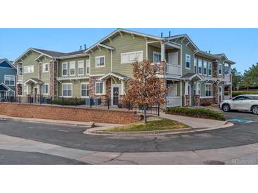 Inviting townhome featuring green siding, stone accents, and a well-maintained front yard in a desirable community at 9461 Ashbury Cir # 104, Parker, CO 80134