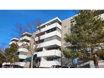 A modern condo building with balconies and well-maintained landscaping on a bright, sunny day at 10650 E Tennessee Ave # 101, Aurora, CO 80012