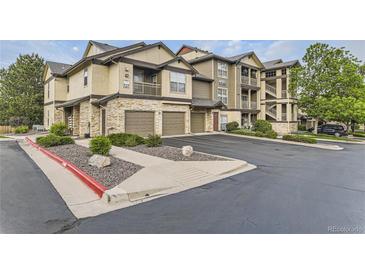 Attractive condo building showcasing attached garages, stone accents, balconies, and well-maintained landscaping at 7418 S Quail Cir # 1312, Littleton, CO 80127