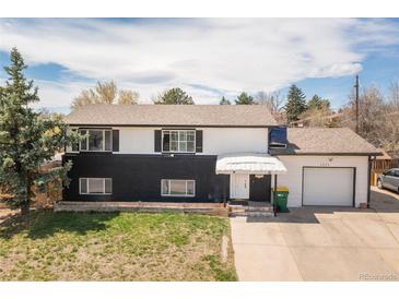 Two-story home with a black and white painted exterior, inviting entrance, and a spacious two-car garage at 7845 Conifer Rd, Denver, CO 80221