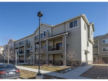 Modern condo building with multiple balconies and attractive landscaping under a blue sky at 11250 Florence St # 28F, Commerce City, CO 80640