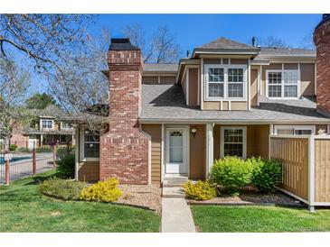 Charming townhome with brick chimney, landscaping, and welcoming entryway at 14271 E Dickinson Dr # F, Aurora, CO 80014
