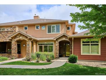 Inviting two-story townhome with stone accents, manicured lawn and front yard landscaping at 8638 Gold Peak Dr # D, Highlands Ranch, CO 80130
