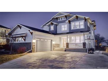 Charming two-story home showcasing a well-manicured lawn, covered porch, and attached two-car garage at 785 Delechant Dr, Erie, CO 80516