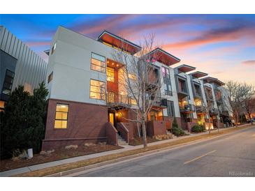 Modern townhome showcases contemporary design, brick facade, with private balcony under a beautiful sunset sky at 1878 W 32Nd Ave, Denver, CO 80211