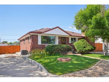Charming red brick house with lush front lawn and a cozy fire pit feature at 11349 Downing Dr, Northglenn, CO 80233