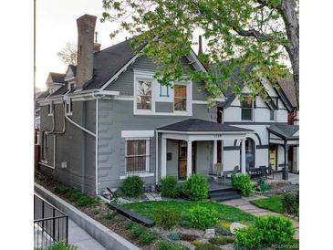 Charming gray two-story home with a covered front porch and well-maintained landscaping at 1729 N Clarkson St, Denver, CO 80218