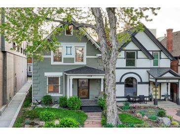 Charming two-story home featuring a well-manicured front yard and inviting front porch with craftsman details at 1729 N Clarkson St, Denver, CO 80218