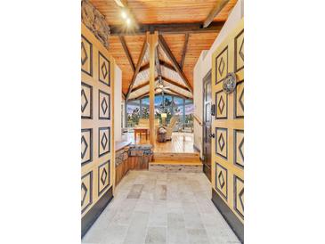 Inviting entryway with vaulted wood ceilings and large windows offering scenic views at 994 Timber Ln, Boulder, CO 80304