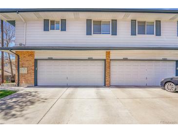 Four garages in townhouse complex with brick pillars and visible address numbers on garage doors at 9759 Lane St, Thornton, CO 80260