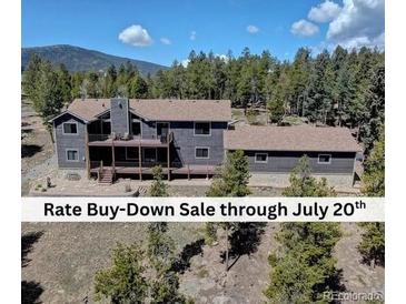 Stunning mountain home featuring a spacious deck and views of a lush, tree-filled landscape at 32091 Black Widow Dr, Conifer, CO 80433