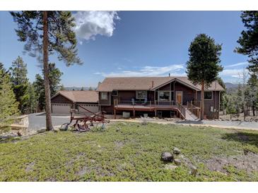 Charming brown home featuring a deck and three-car garage, nestled on a scenic lot with mature trees at 32091 Black Widow Dr, Conifer, CO 80433