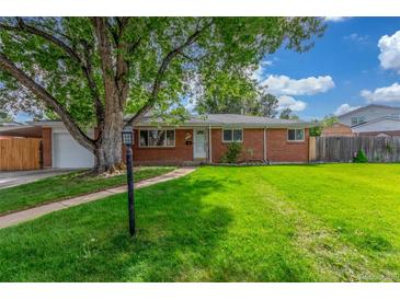 Charming brick home featuring a well-manicured lawn and mature tree, providing shade and curb appeal at 10784 Allendale Dr, Arvada, CO 80004