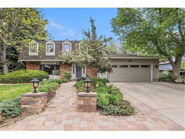 Charming home featuring manicured landscaping, brick accents, and a two-car garage at 10158 E Fair Cir, Englewood, CO 80111