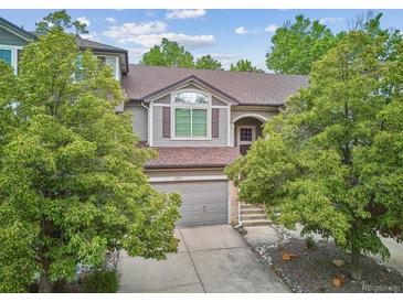 Charming home featuring gray siding, mature trees, and a two-car garage at 1441 S Ulster St, Denver, CO 80231