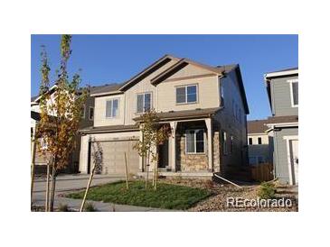 Charming two-story home with stone accents, covered porch, and a two-car garage at 15305 W 93Rd Ave, Arvada, CO 80007