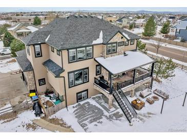 Spacious two-story home features a large deck, stone accents, and a well-manicured yard in a suburban neighborhood at 6985 Fallon Cir, Castle Rock, CO 80104
