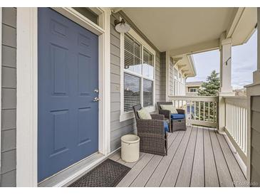 Inviting front porch with cozy seating and stylish blue door at 9519 Pearl Cir # 105, Parker, CO 80134