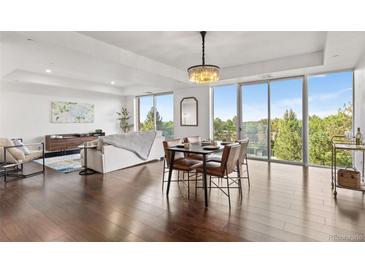 Bright, open-concept living and dining space featuring hardwood floors and panoramic views at 1900 E Girard Pl # 505, Englewood, CO 80113