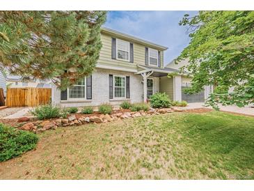 Charming two-story home featuring a well-maintained lawn and attractive landscaping at 16051 E Alabama Dr, Aurora, CO 80017
