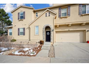 Tan two-story home with a two-car garage and landscaping at 10587 Parkington Ln # B, Highlands Ranch, CO 80126