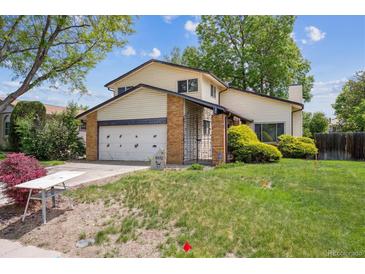 Charming two-story home with a well-maintained lawn, attached garage, and inviting curb appeal on a sunny day at 8552 Gray Ct, Arvada, CO 80003