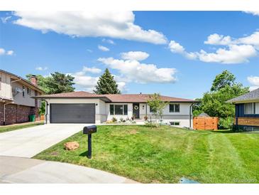 Charming one-story home with a well-maintained lawn, mature trees, and an attached garage in a suburban neighborhood at 1354 S Wright St, Lakewood, CO 80228