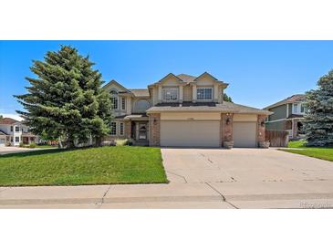 Charming two-story home featuring a well-manicured lawn and an attached three-car garage at 11506 Greenbriar Ln, Parker, CO 80138