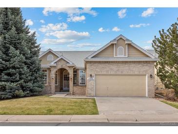 Charming single-Gathering home featuring a brick facade, arched entryway, and well-manicured lawn at 5322 Shetland Ct, Highlands Ranch, CO 80130