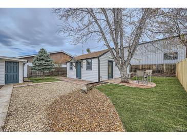 Cozy home featuring a gravel driveway, well-maintained lawn, and an inviting outdoor seating area at 3379 S Eliot St, Englewood, CO 80110