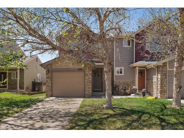 Charming two-story home featuring a two-car garage and a well-maintained front yard with mature trees at 4437 Cornish Way, Denver, CO 80239