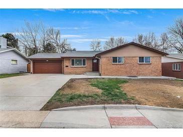 Charming brick home featuring an attached garage and a well-manicured front yard at 2203 S Harlan St, Denver, CO 80227
