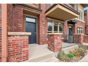 Charming brick townhouse featuring a modern front door and exterior lighting at 8962 E Otero Pl, Centennial, CO 80112