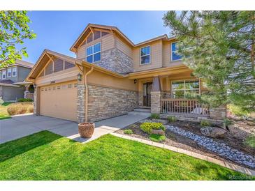 Charming two-story home showcasing stone accents, covered porch, and manicured landscaping at 24316 E Ottawa Ave, Aurora, CO 80016