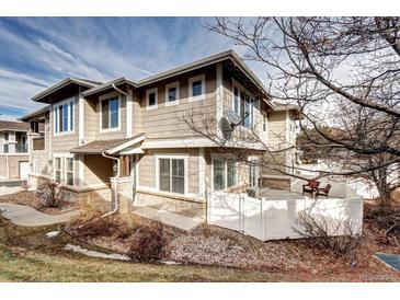 Charming townhome featuring a private patio with a white fence and mature landscaping at 10141 Autumn Blaze Trl, Highlands Ranch, CO 80129