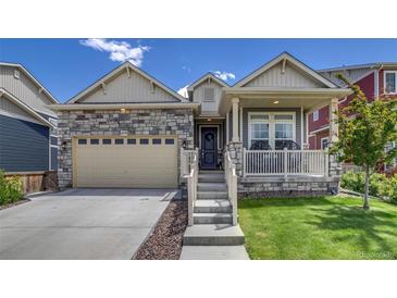 Charming single Gathering home with a stone facade, two car garage, and a cozy front porch with beautiful landscaping at 16578 E 111Th Pl, Commerce City, CO 80022