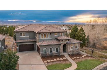Stunning home featuring a beautiful tile roof and stone accents with a mountain view at 237 Maplehurst Dr, Highlands Ranch, CO 80126